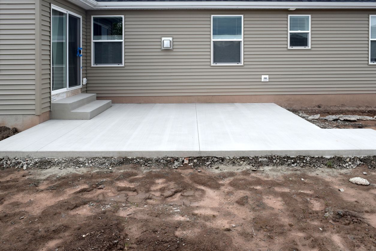 A concrete patio is being built in front of a house.
