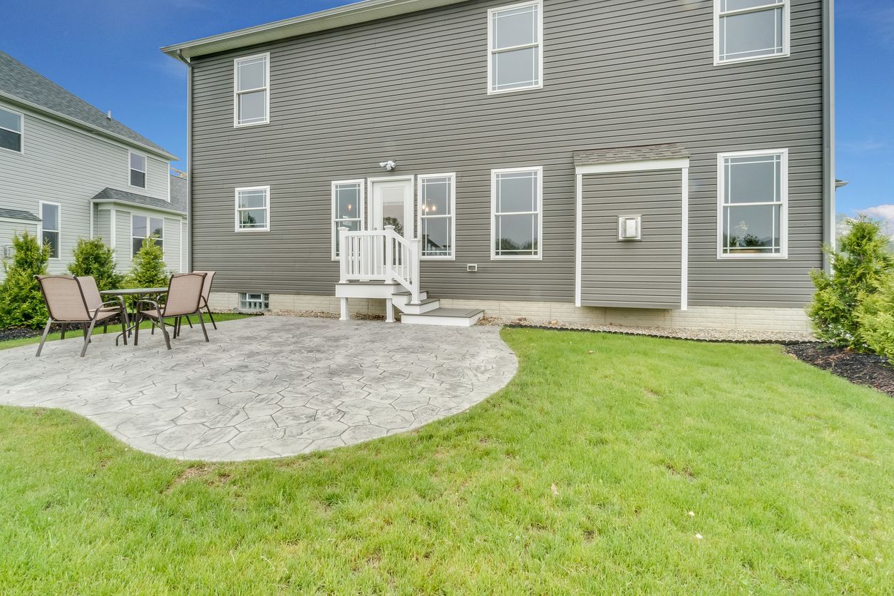 The backyard of a house with a patio and a table and chairs.