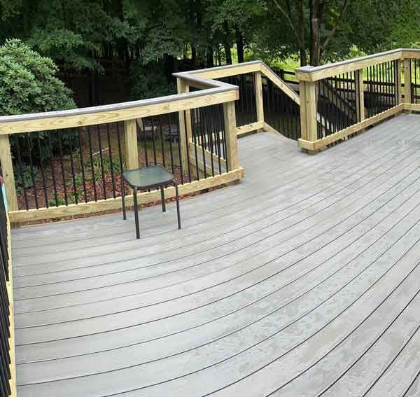 A wooden deck with a chair and a table on it.