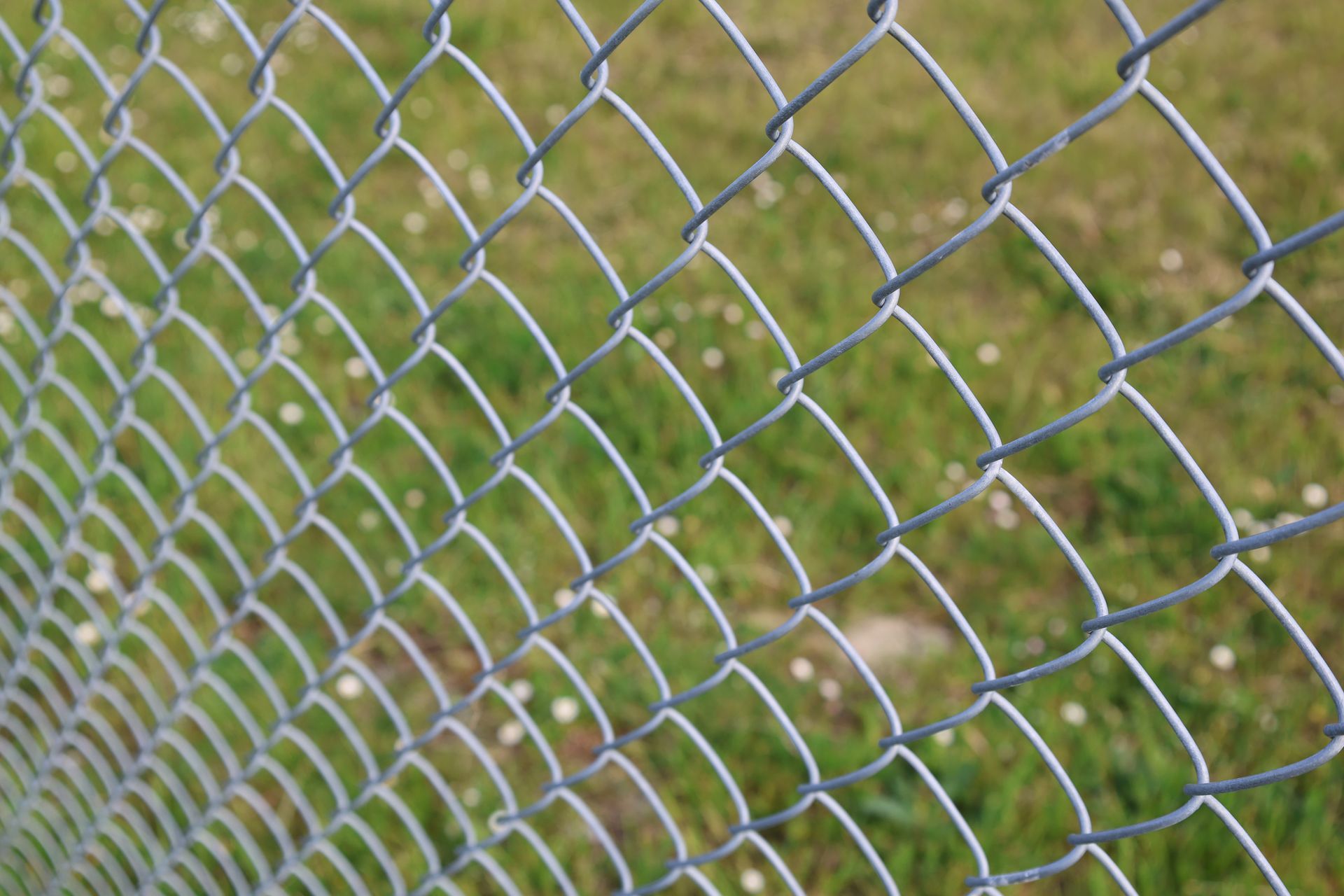 Gloved hands hammering a nail into a wooden fence panel Gloved hands hammering a nail into a wooden fence panel