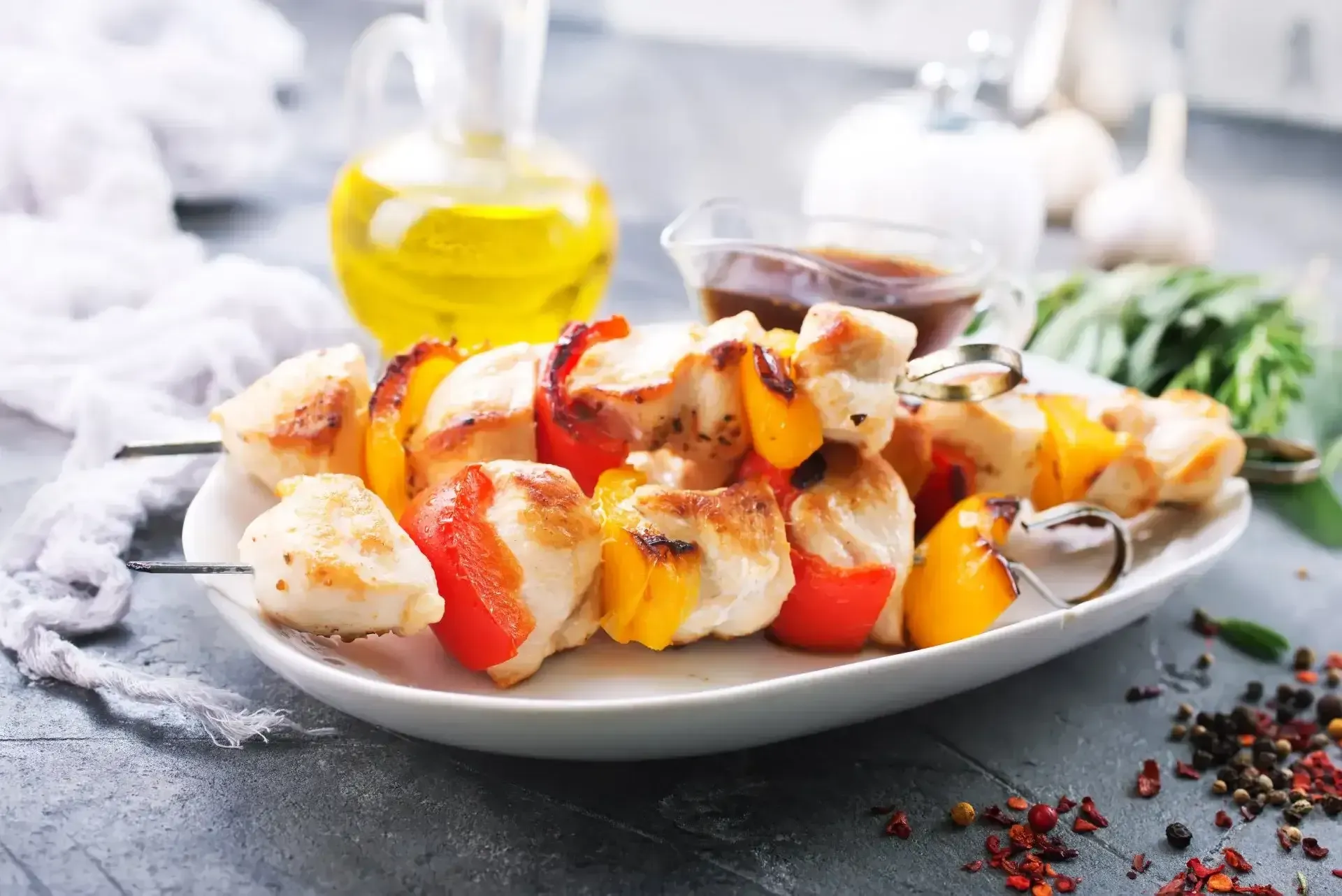 Restaurantes Florencia Caquetá con brochetas de pollo y pimentón servidas con salsa y aceite de oliva.