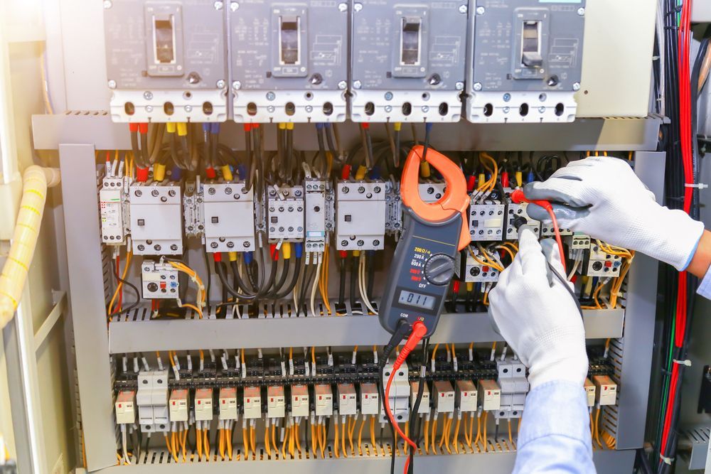 Electrician Uses a Multimeter to Inspect Electrical Components in an Industrial Panel — Carl Voss Electrical In Urangan, QLD
