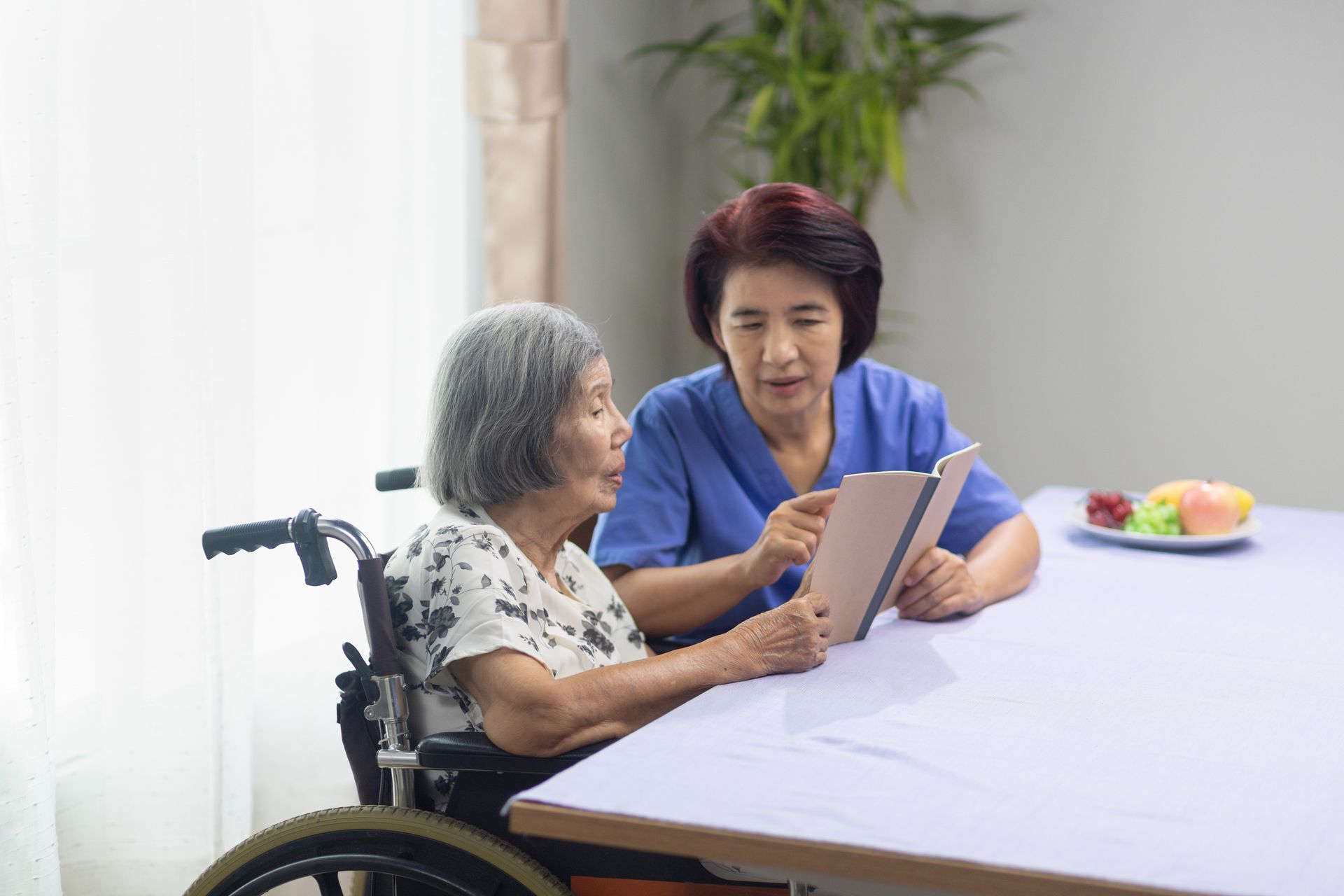 speech therapist conducting voice exercise with elderly patient in wheelchair