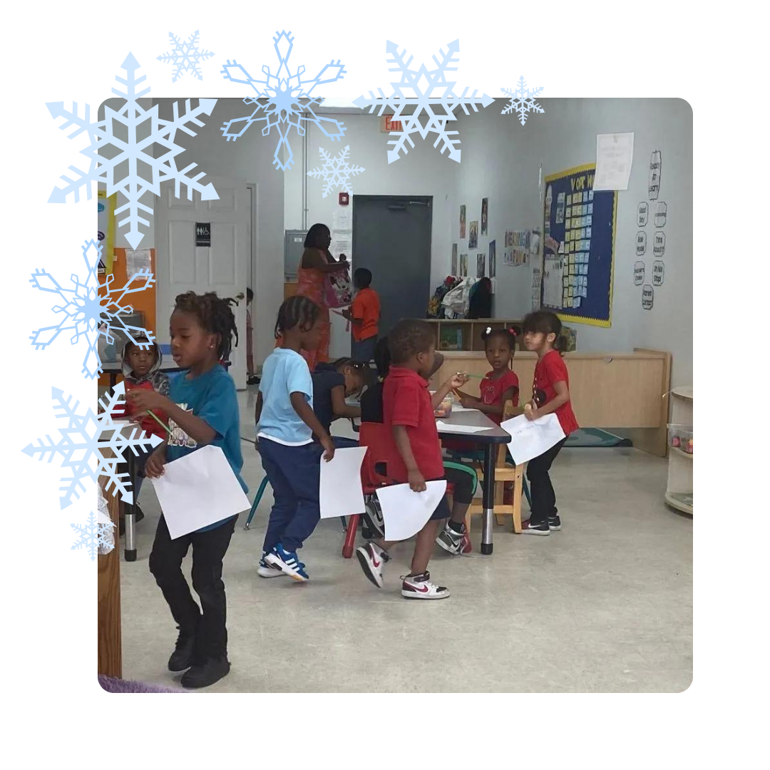 A group of children are standing in a room with snowflakes on the wall