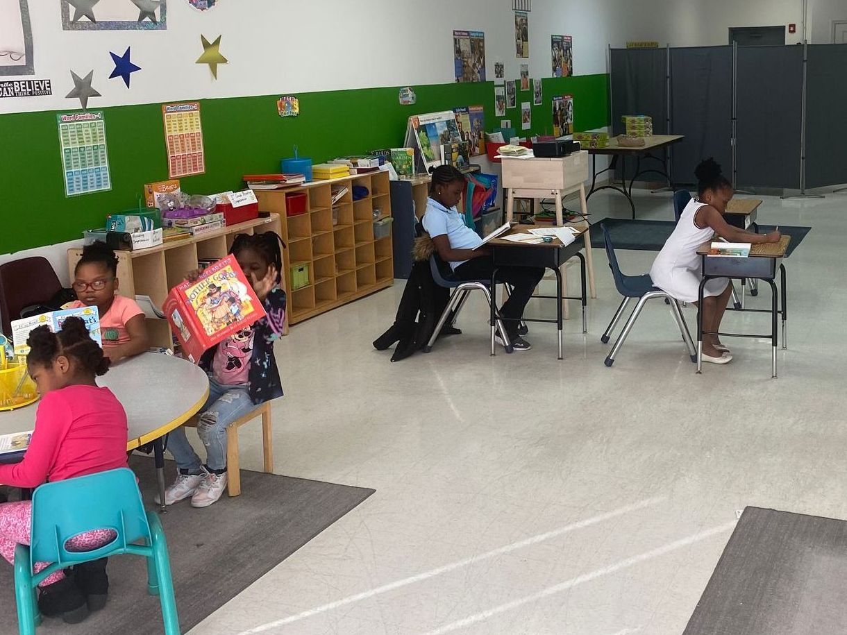 A group of children are reading books in a classroom