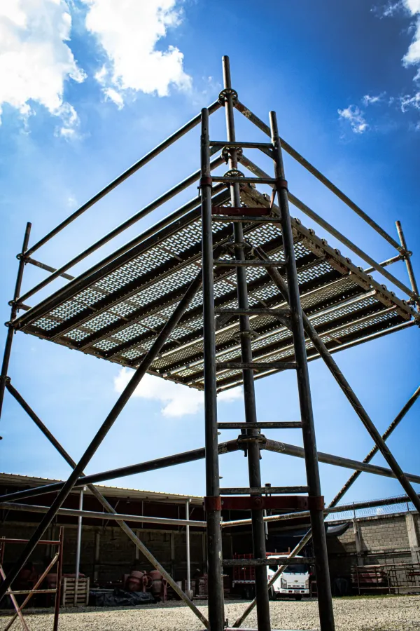Estructura metálica de andamio contra un cielo azul en una obra de construcción.
