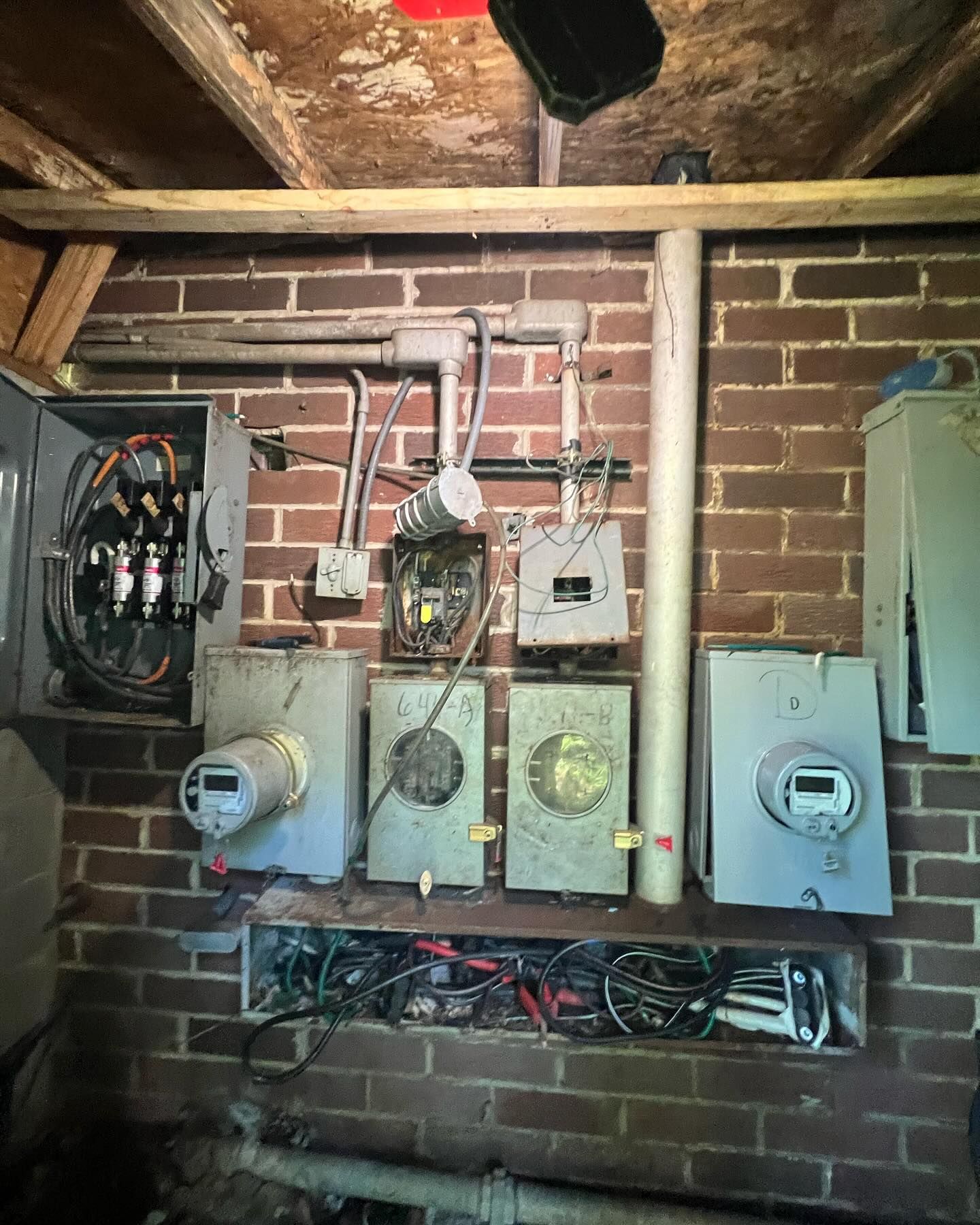 A brick wall with a bunch of electrical equipment on it