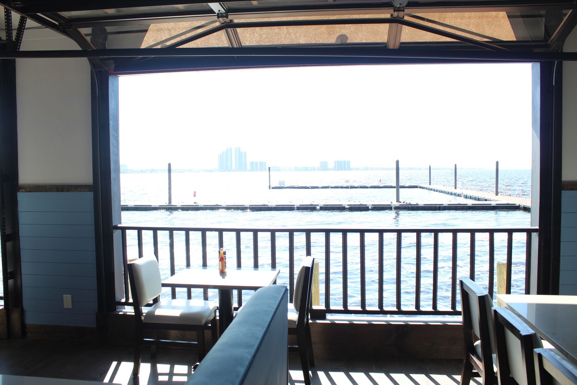A restaurant with tables and chairs and a view of the water