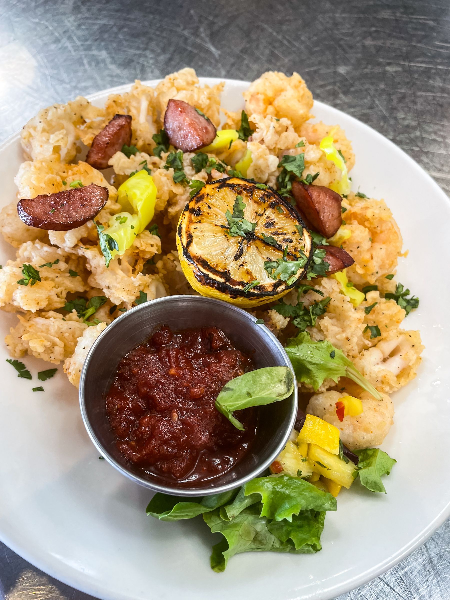 A plate of food with a small bowl of sauce on the side.