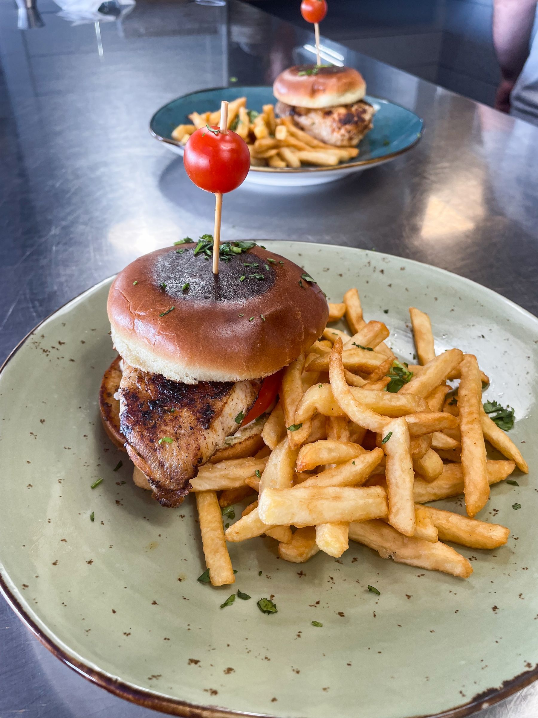 A plate of food with a sandwich and french fries on a table.