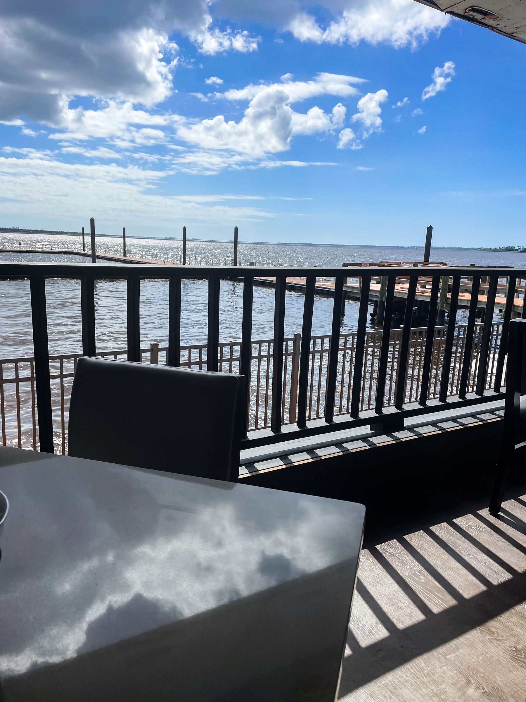 A table and chairs on a balcony overlooking the ocean