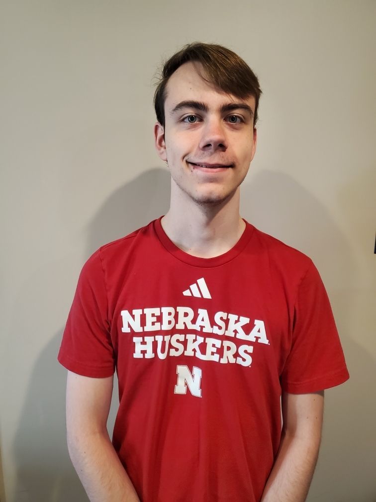 A young man wearing a red nebraska huskers shirt