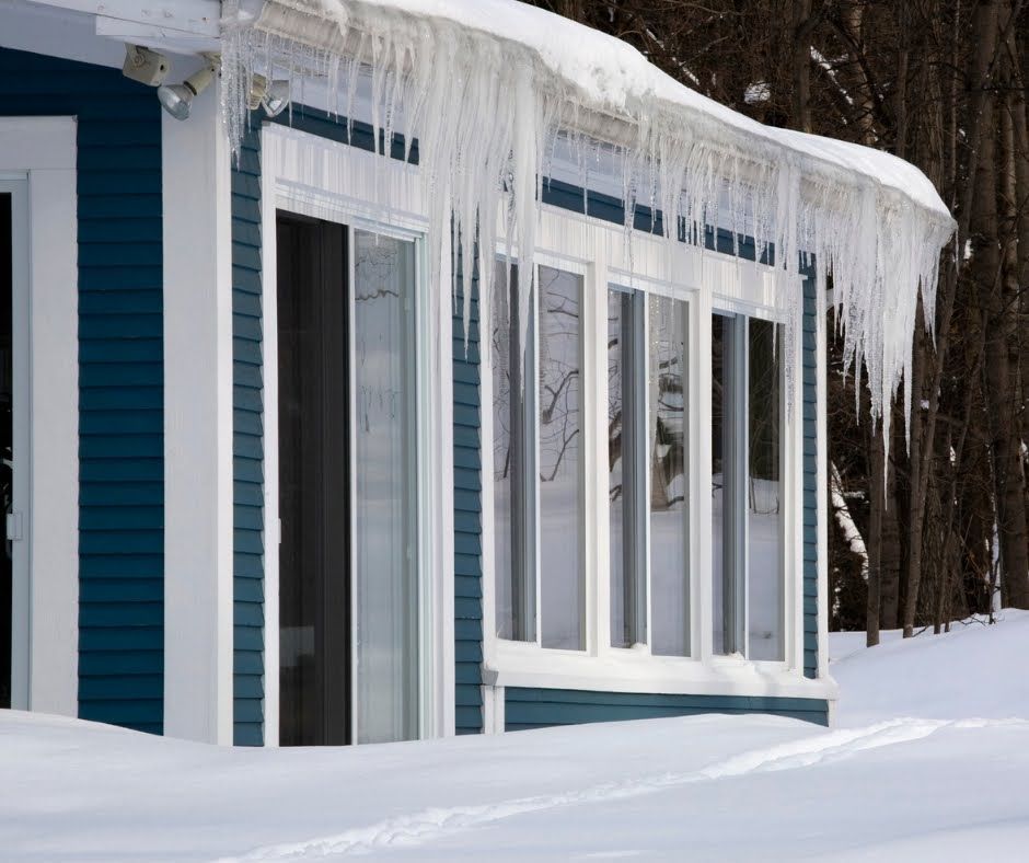 Icicles are hanging from the roof of a house