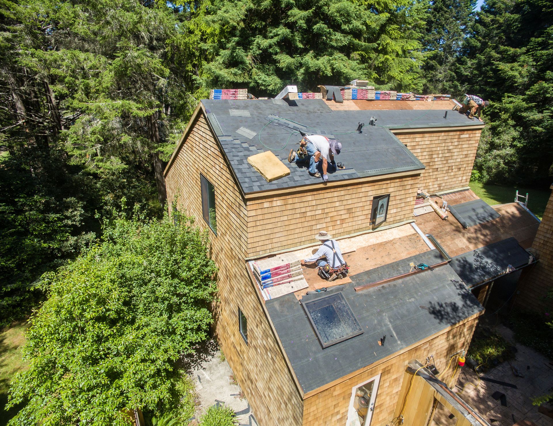 Roofing crew installing shingles on a home roof.