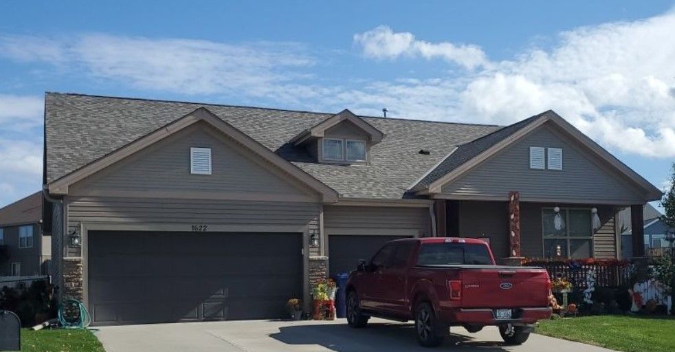 A red truck is parked in front of a house