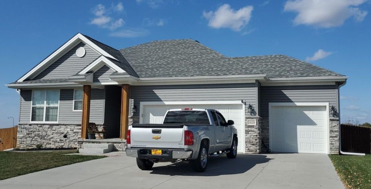 A white truck is parked in front of a house.