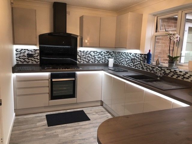 A kitchen with white cabinets and a black stove top oven