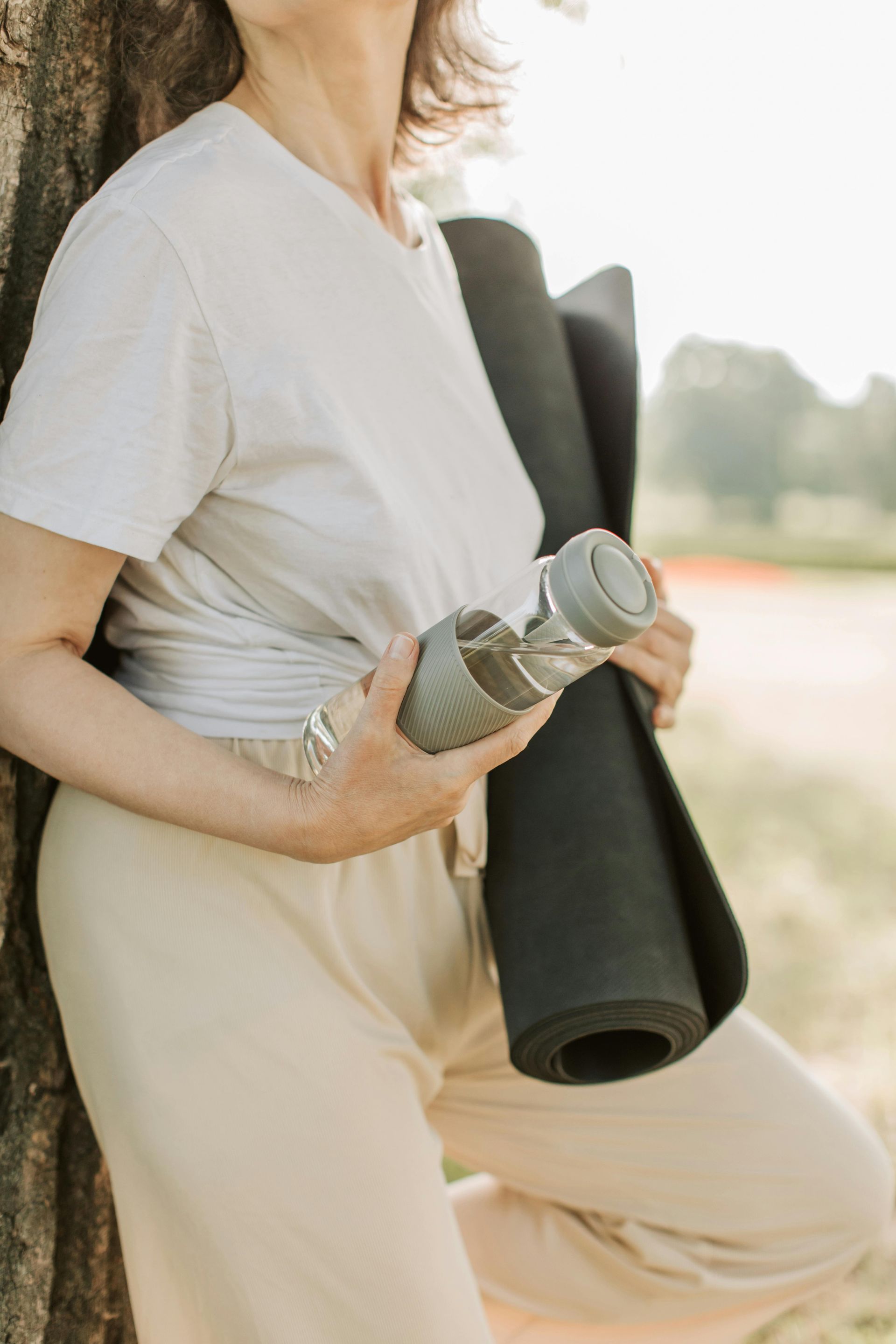 woman with a yoga mat and water bottle for losing weight