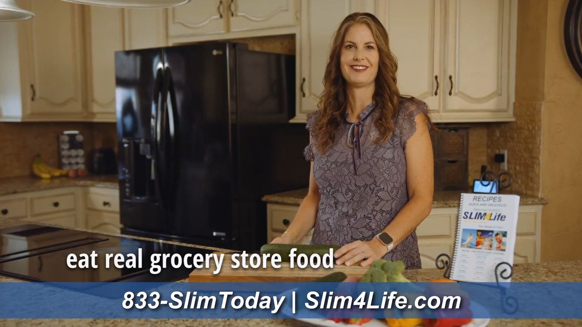A woman in a kitchen with a sign that says eat real grocery store food