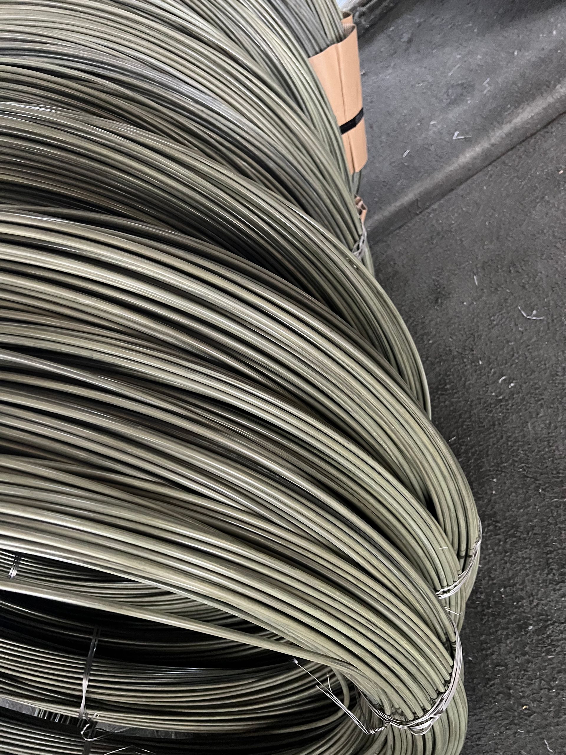 Coil of thick, silver-grey metal wire.