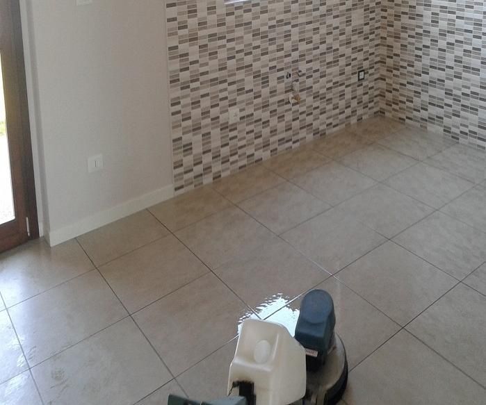 Stanza vuota piastrellata, con una parete decorativa a motivi e un piccolo elettrodomestico sul pavimento, vicino alla fotocamera