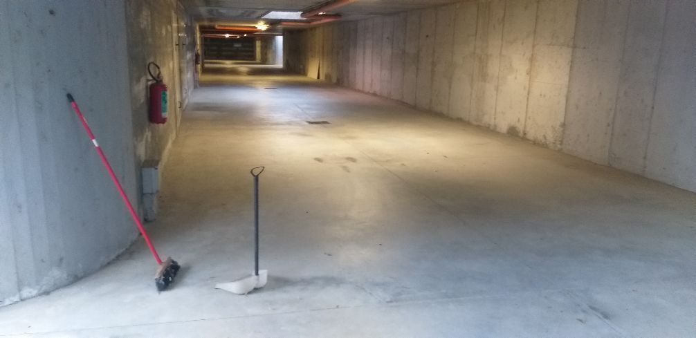 Tunnel di cemento vuoto, con una scopa e una piccola pala appoggiate alla parete.