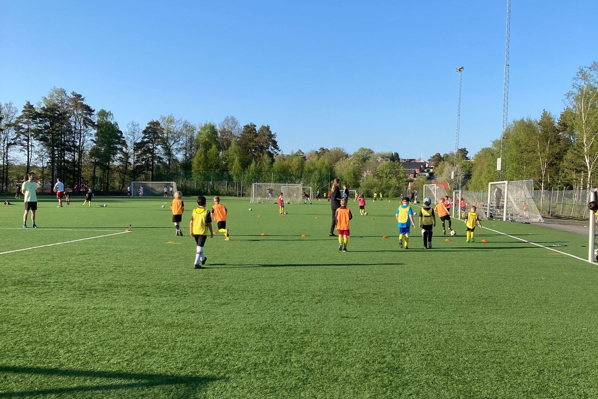 Barn som spelar fotboll i solen.
