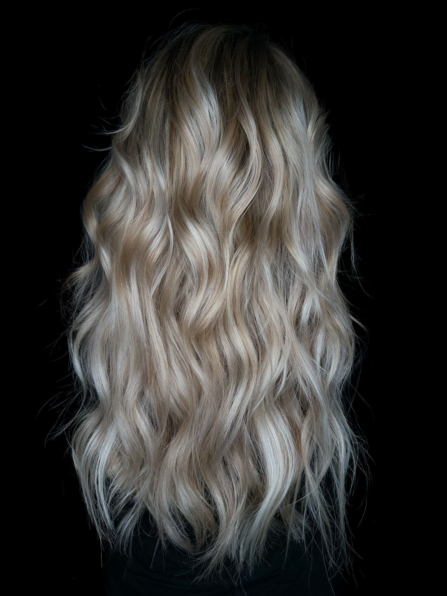 Long wavy blonde hair on a black background