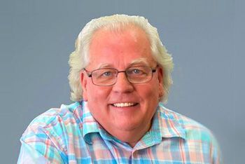 Man With White Hair and Glasses Smiling at the Camera; Wearing a Plaid Shirt — Immigration Agents in Cairns North, QLD