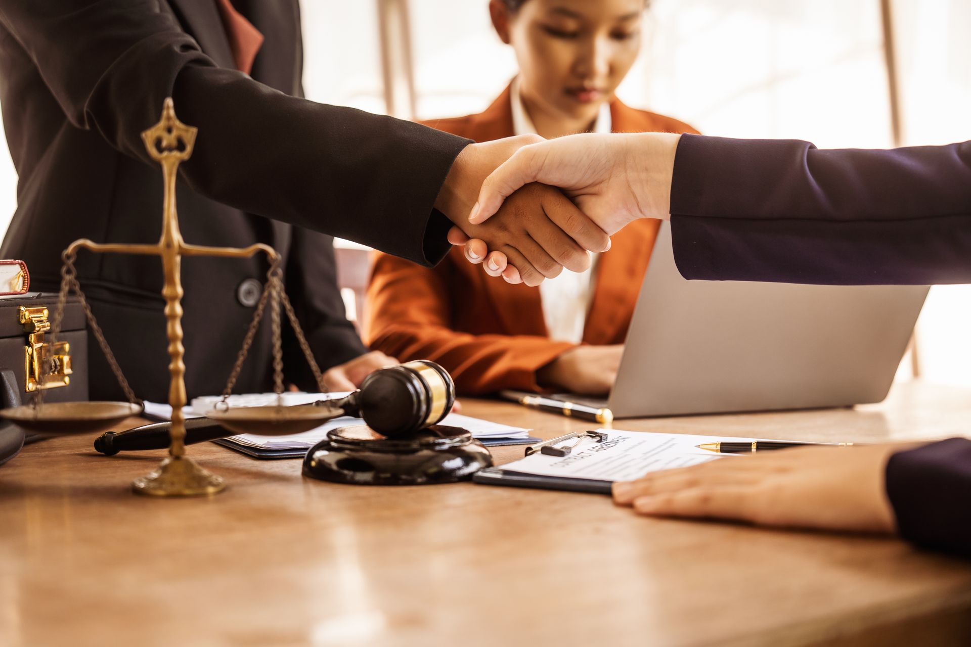 People Shaking Hands at a Legal Table, Scales of Justice — Immigration Agents in Cairns North, QLD