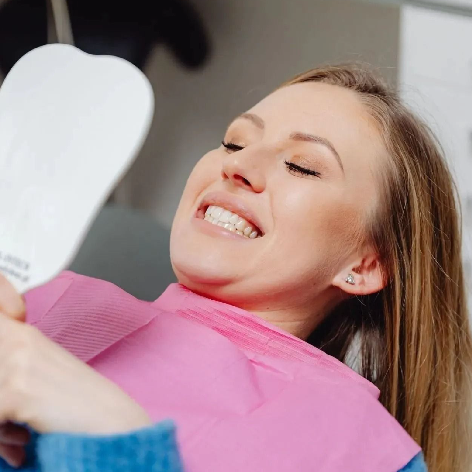 Hands in blue gloves holding a dental model with teeth.