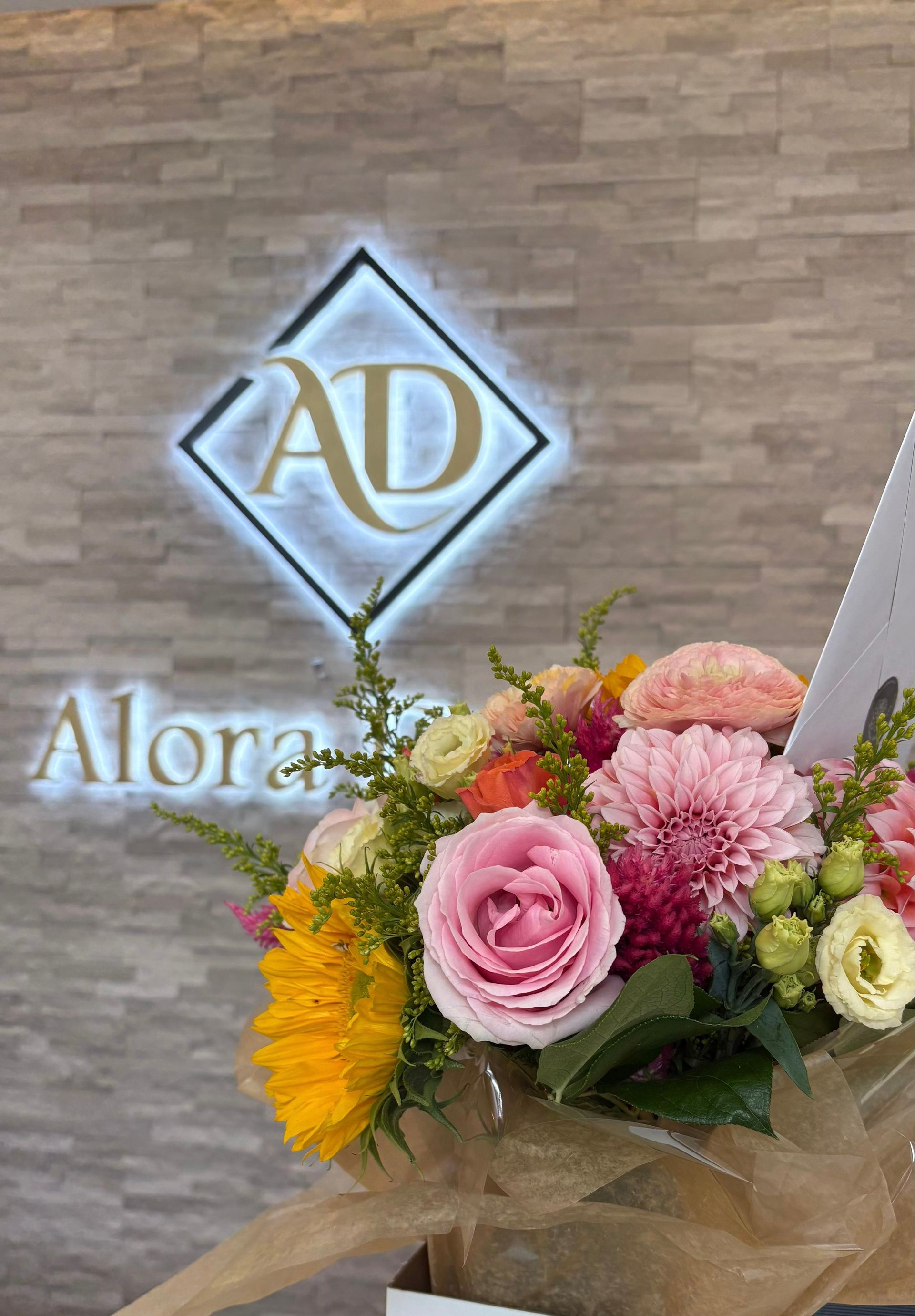Bouquet of colorful flowers in front of a sign with 