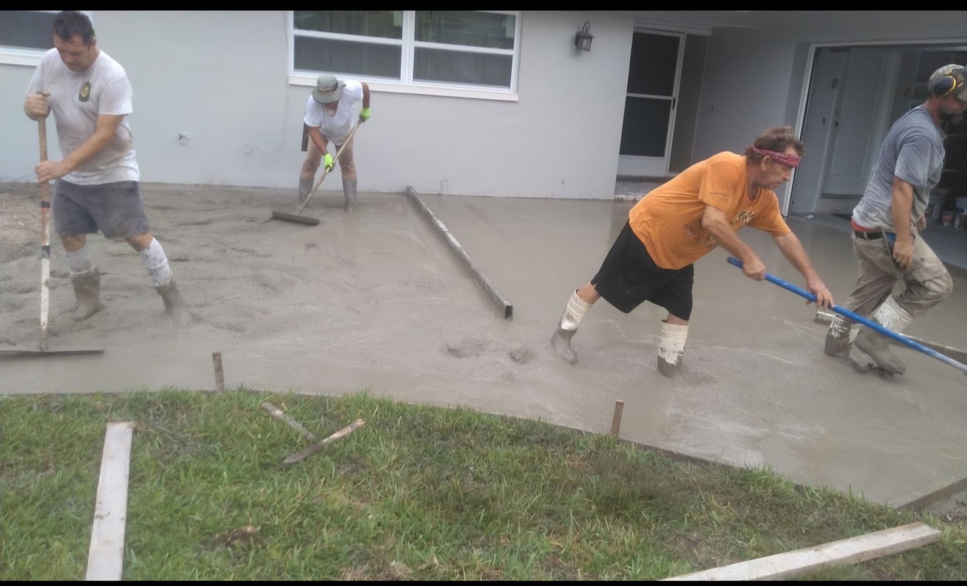 A group of men are working on a concrete patio.