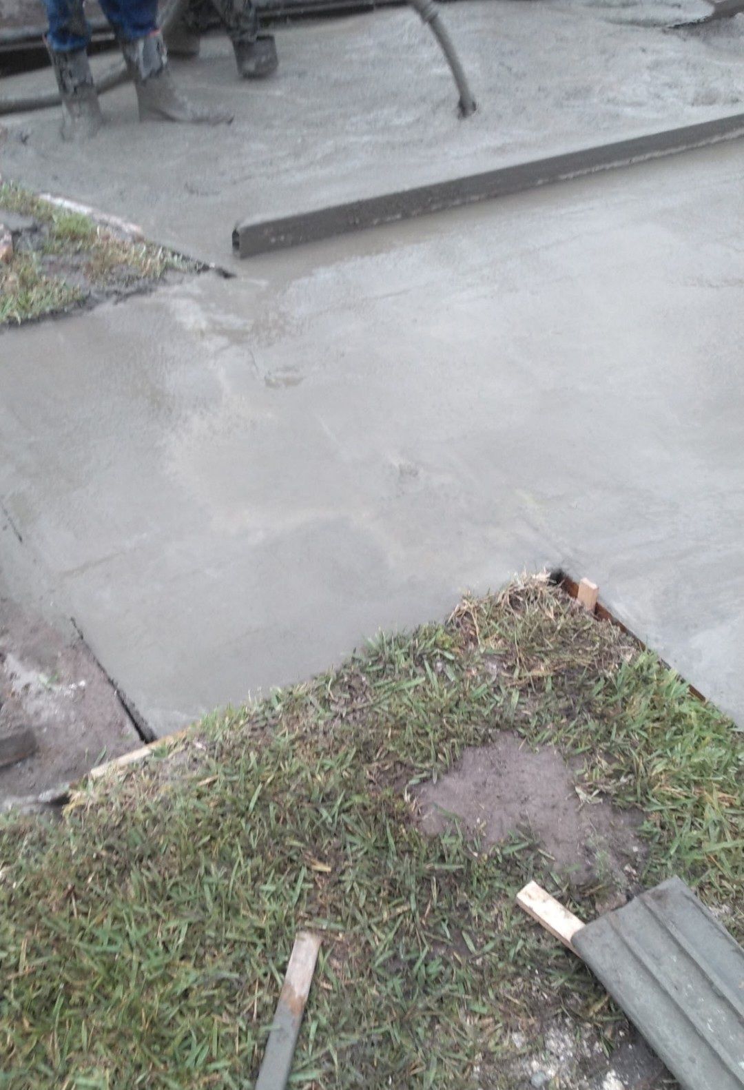 A person is pouring concrete on a sidewalk.