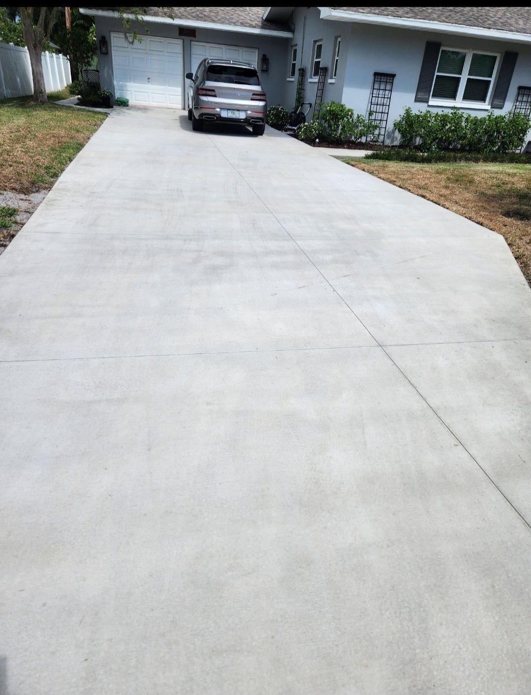 A car is parked in a driveway next to a house.
