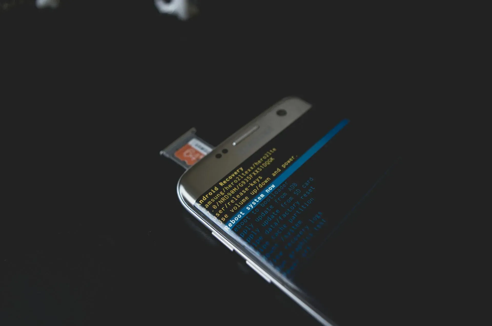 Close-up of a Black Smartphone With Its Sim Card Tray Open, Reflecting a Dark Surface — Micromac Computers in Charmhaven, NSW