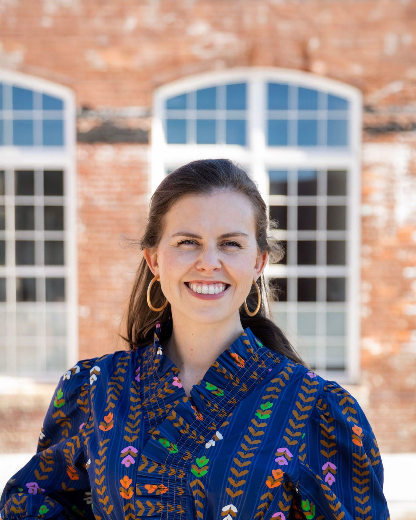 Felicia Keeling smiling in a black sweater standing outdoors in front of a brick building