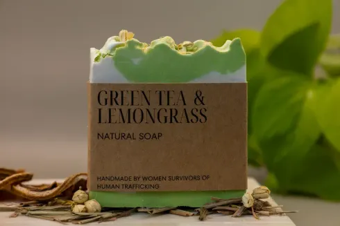 Green tea and lemongrass natural soap bar with green wavy top on a rustic surface