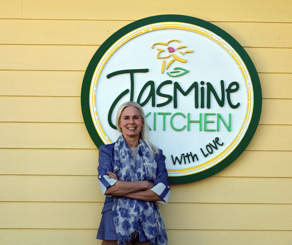 Jasmine Kitchen storefront sign with green circular logo outside a yellow building