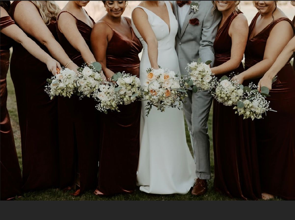 A bride and groom pose for a picture with their bridesmaids