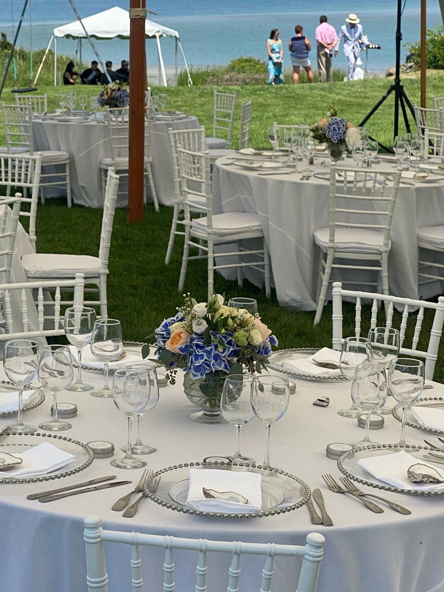 A table set for a wedding reception with a vase of flowers on it
