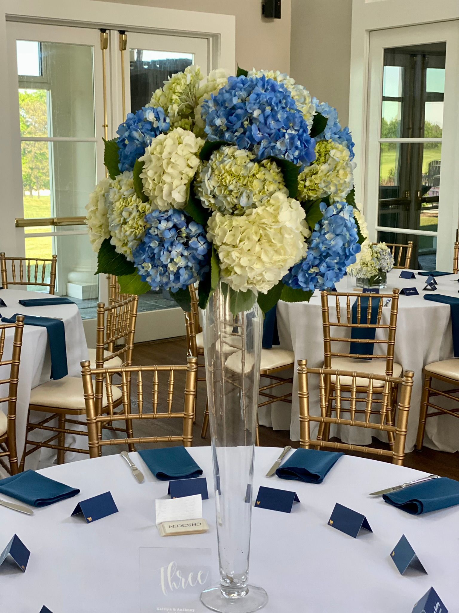 A vase filled with blue and white flowers is on a table.