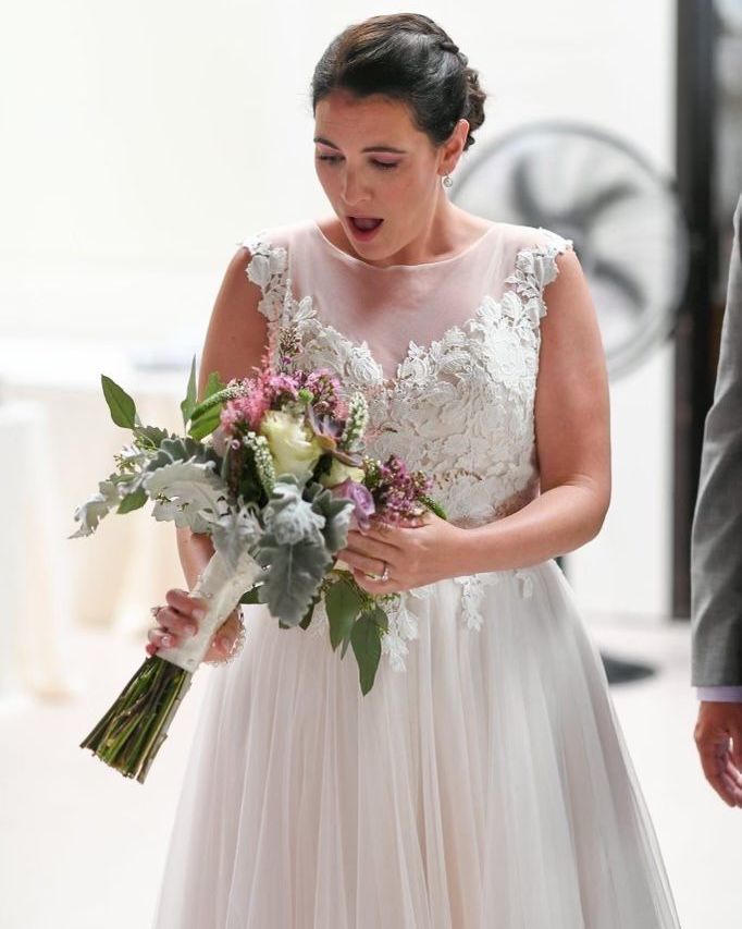 A woman in a wedding dress is holding a bouquet of flowers