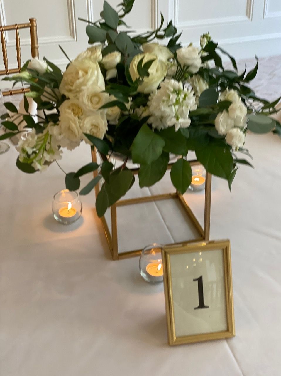 A table with flowers and candles and a table number 1