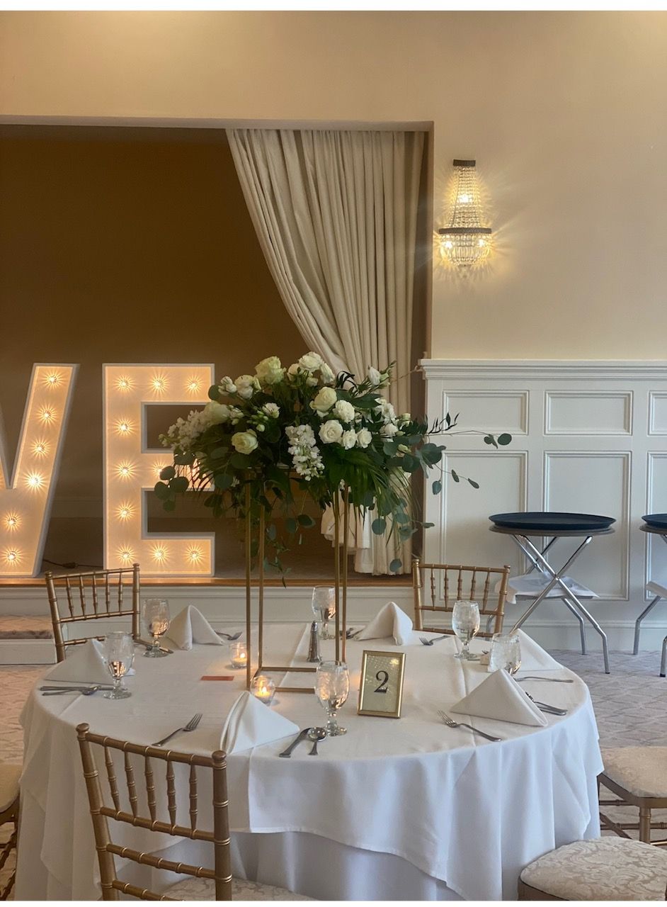 A room with tables and chairs set up for a wedding reception.