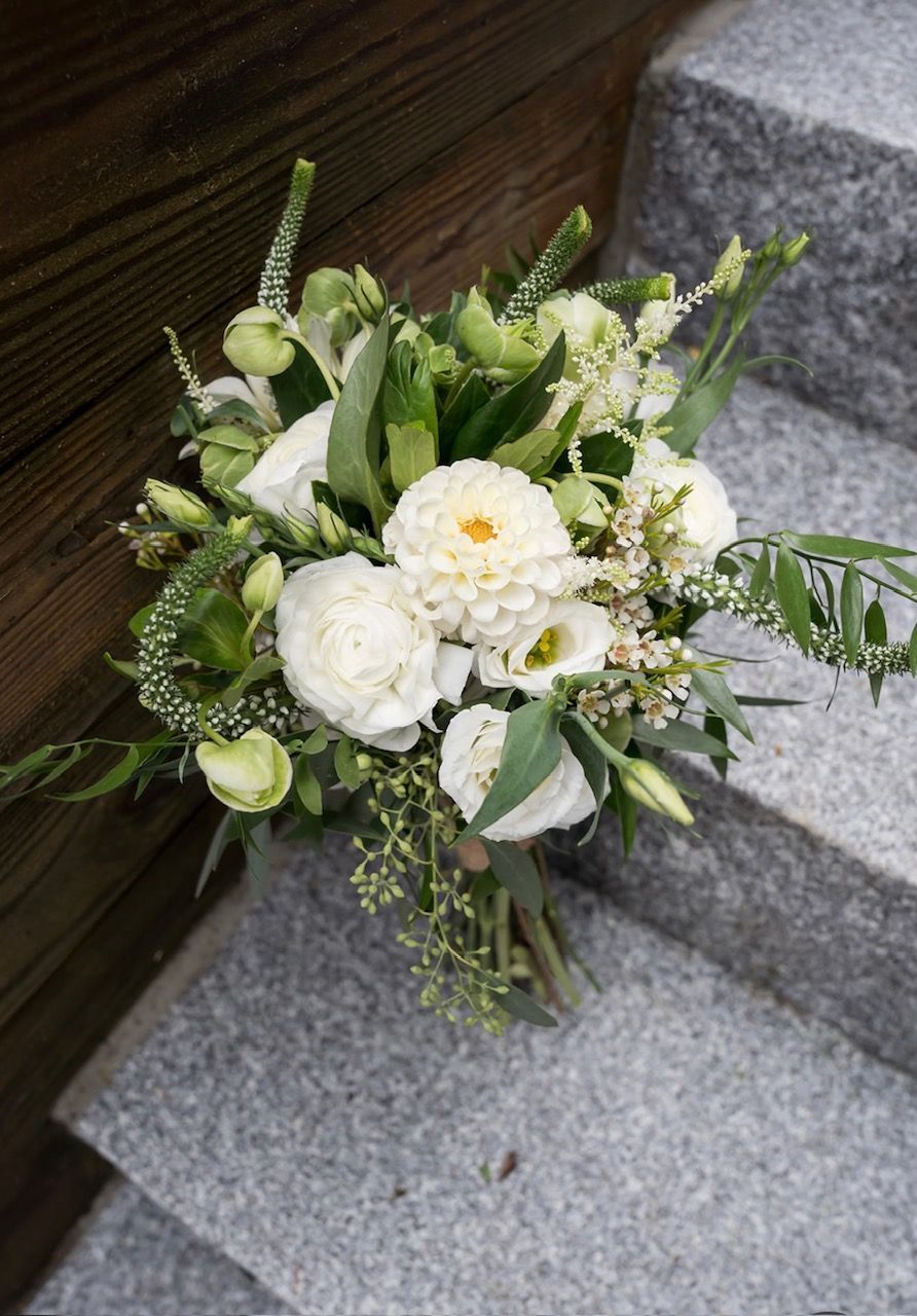 A bouquet of white flowers is sitting on top of a set of stairs.