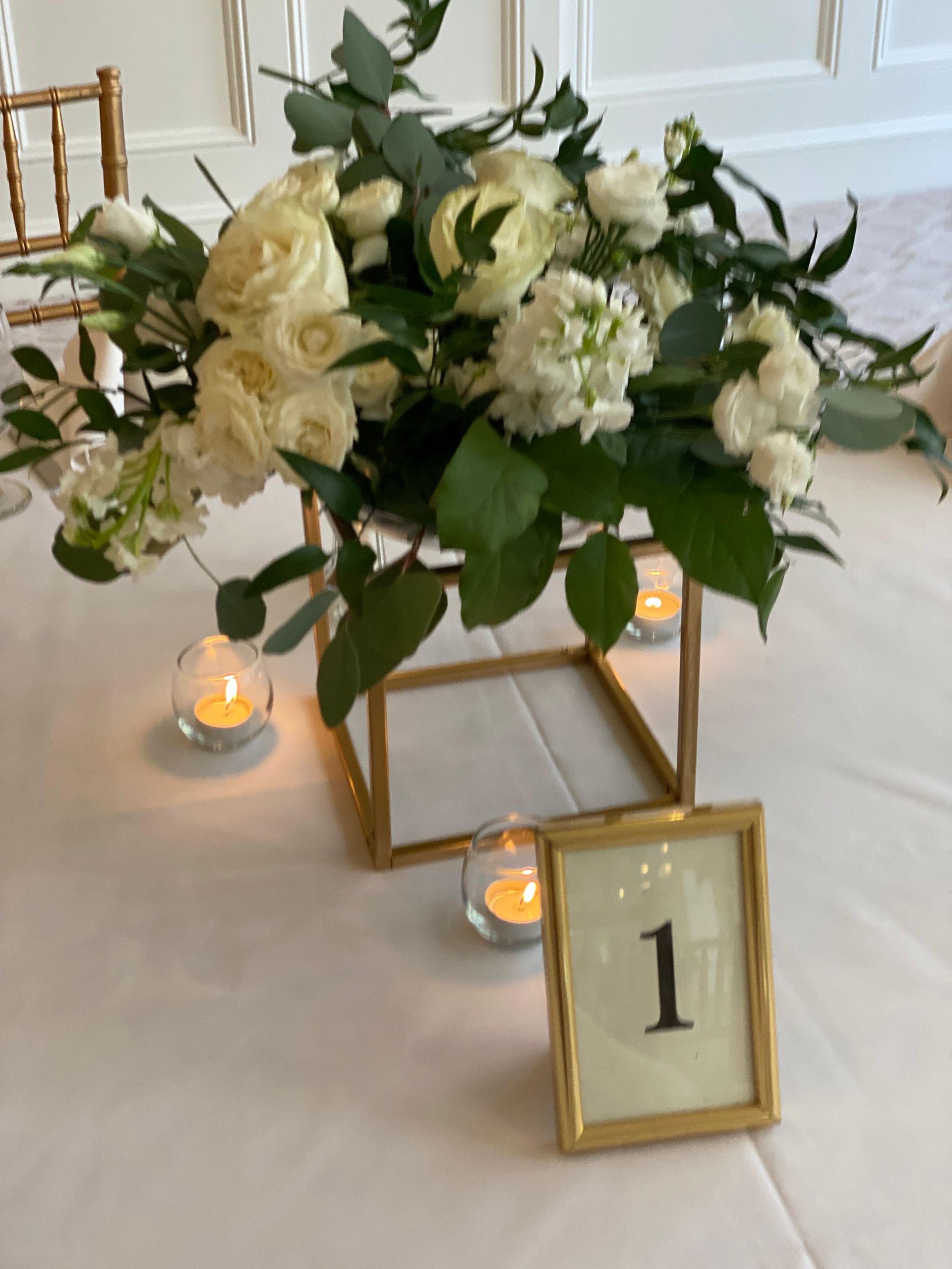 A table with flowers and candles and a table number 1