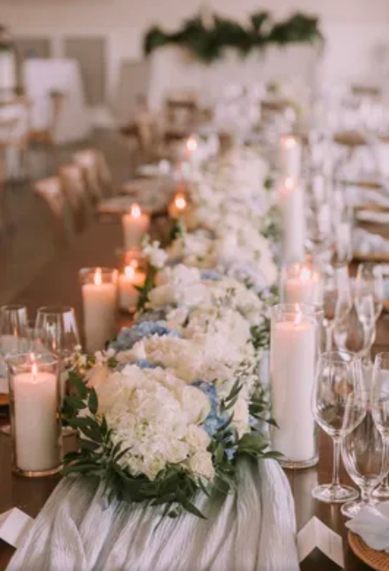 A long table with candles and flowers on it.