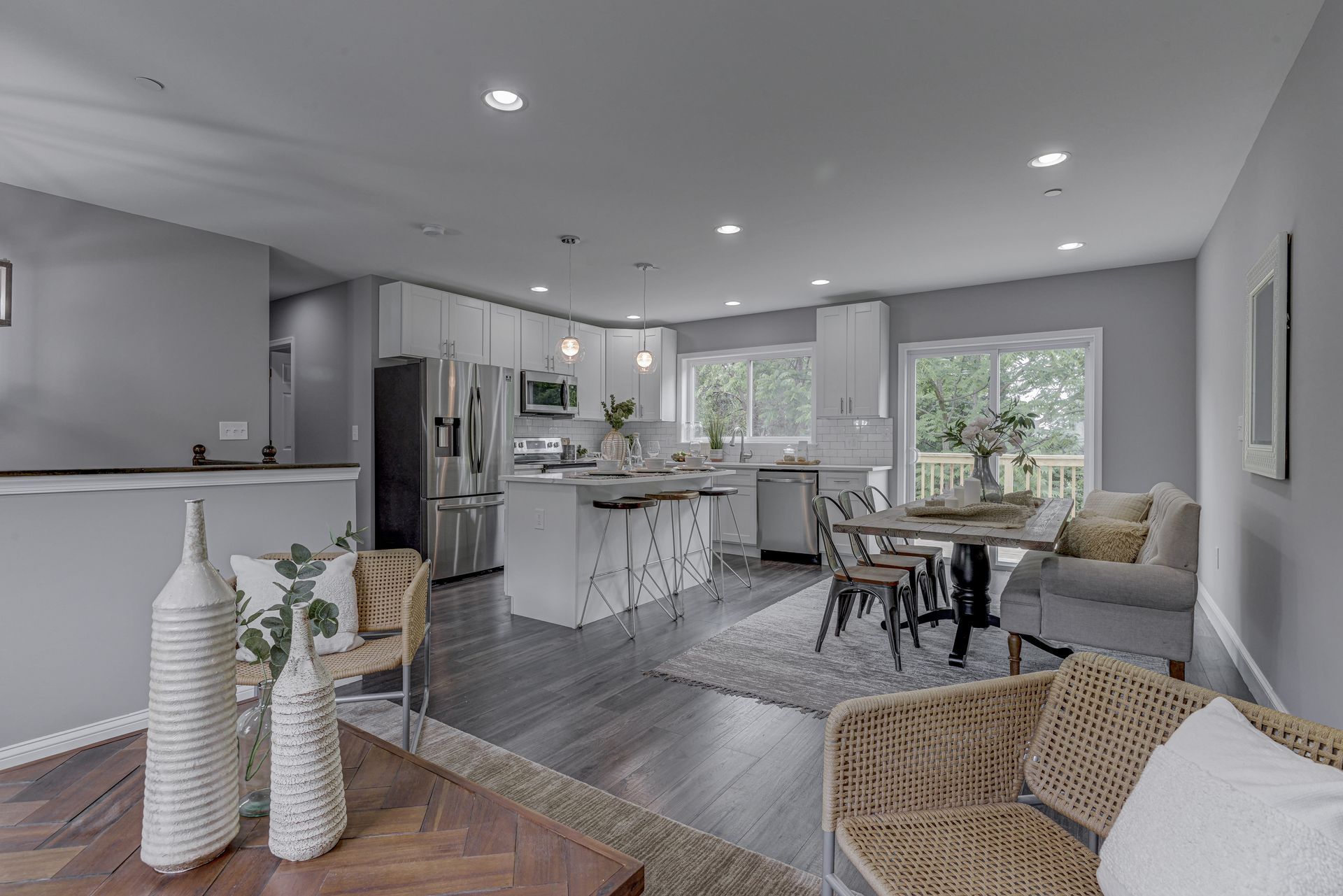 A living room with a table , chairs , and a refrigerator.