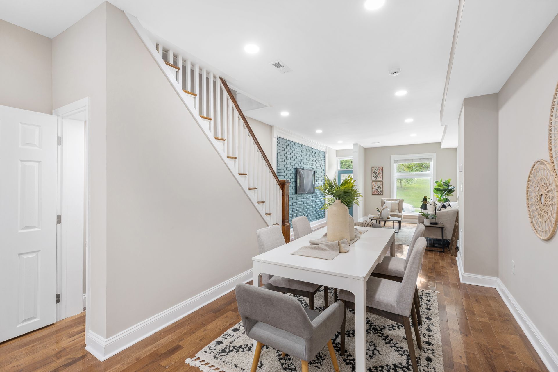 A dining room table and chairs in a house with stairs.